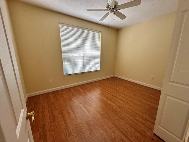 spare room featuring ceiling fan, hardwood / wood-style flooring, and a textured ceiling