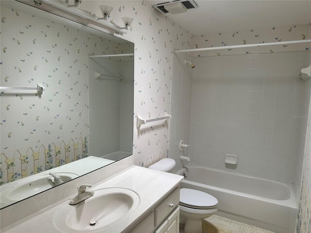 full bathroom with vanity, tiled shower / bath combo, and toilet