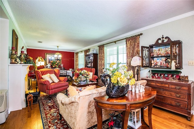 living room with a textured ceiling, light hardwood / wood-style floors, and ornamental molding