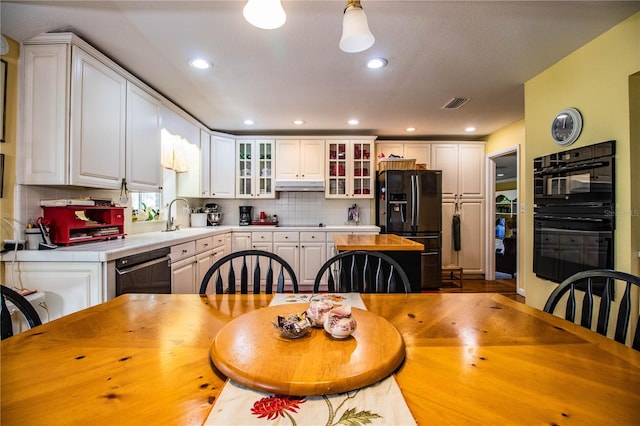 kitchen featuring black appliances, white cabinets, sink, tasteful backsplash, and decorative light fixtures