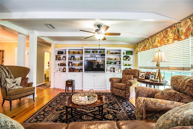 living room featuring ornate columns, ceiling fan, and light wood-type flooring