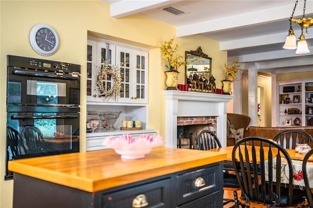 bar with beamed ceiling, wood counters, double oven, and a brick fireplace