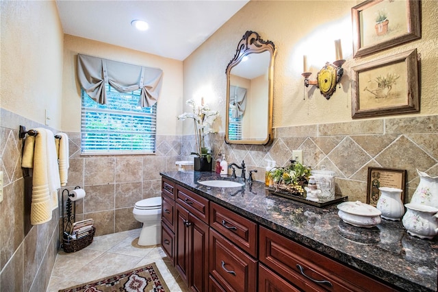 bathroom with tile patterned flooring, vanity, tile walls, and toilet