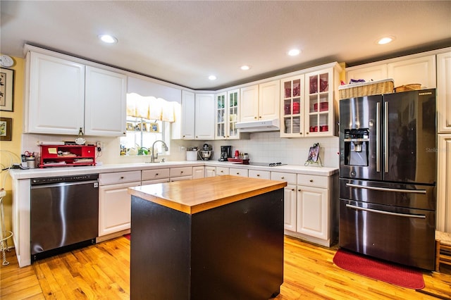 kitchen with white cabinets, wooden counters, light hardwood / wood-style floors, a kitchen island, and black appliances