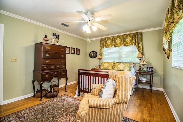 bedroom with wood-type flooring, ornamental molding, and multiple windows