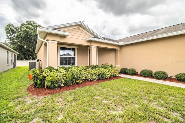 view of front of home featuring central AC and a front lawn