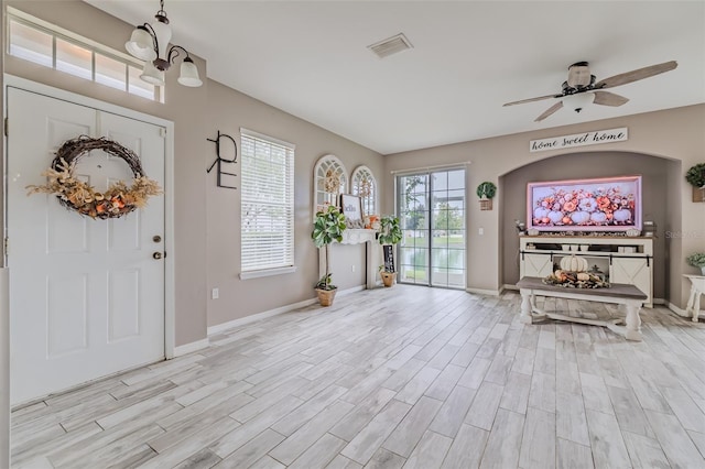 entrance foyer featuring ceiling fan with notable chandelier and light hardwood / wood-style flooring