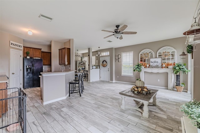 interior space featuring light wood-type flooring, sink, and ceiling fan