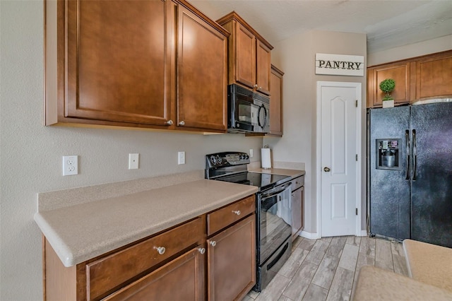 kitchen featuring light hardwood / wood-style floors and black appliances