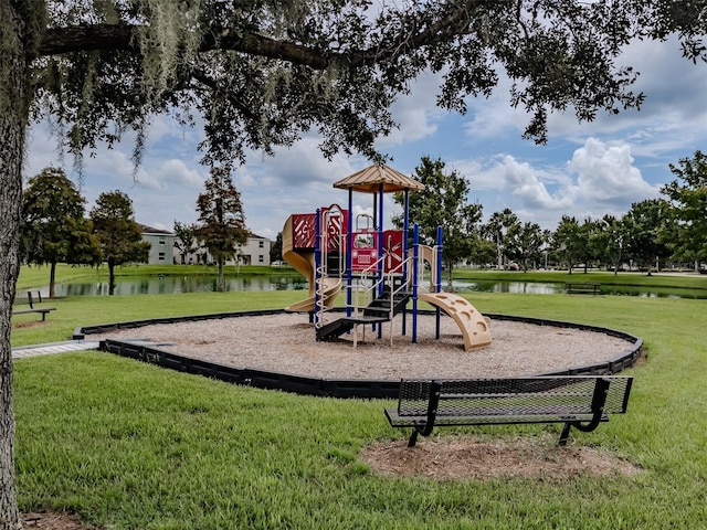 view of playground with a lawn and a water view