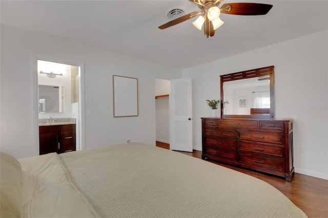 bedroom with hardwood / wood-style floors, ensuite bath, and ceiling fan