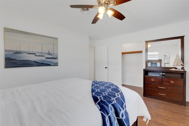 bedroom with ceiling fan, wood-type flooring, and a closet