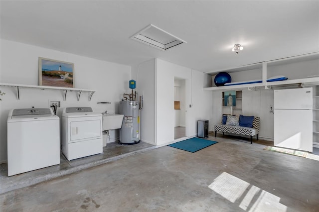 garage with washing machine and dryer, white fridge, electric water heater, and sink