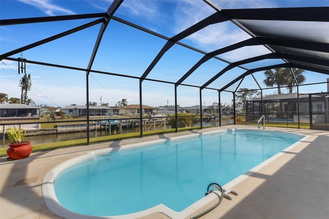 view of swimming pool with a water view, a patio area, and glass enclosure