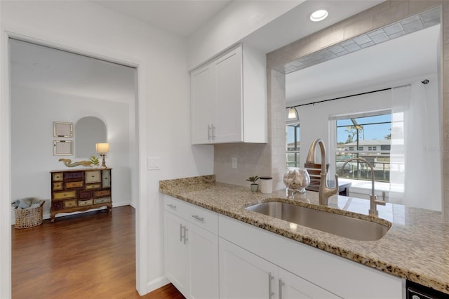 kitchen featuring light stone counters, sink, dark hardwood / wood-style flooring, and white cabinets