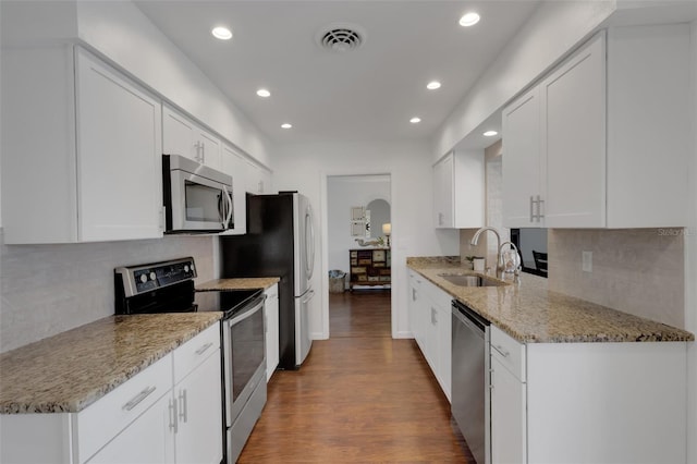 kitchen featuring appliances with stainless steel finishes, sink, white cabinets, and light stone counters