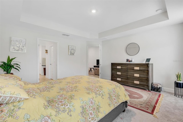 carpeted bedroom with a tray ceiling