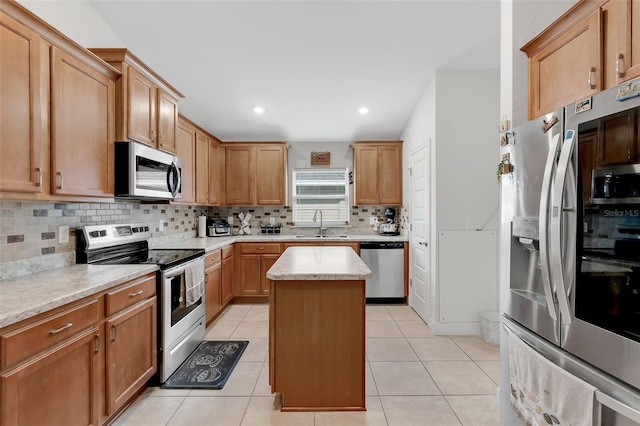 kitchen with stainless steel appliances, backsplash, light tile patterned floors, and a center island