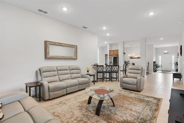 tiled living room featuring a notable chandelier