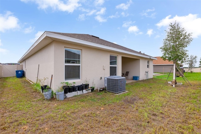 back of house with a yard and central AC