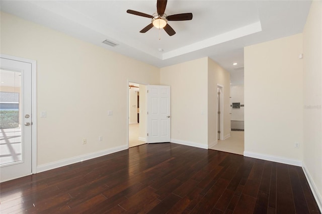 unfurnished room featuring dark hardwood / wood-style floors and a raised ceiling