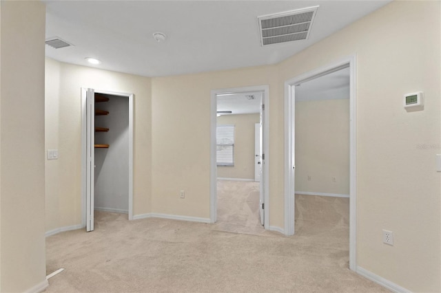 hallway featuring light colored carpet