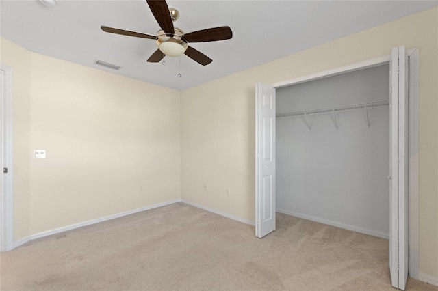 unfurnished bedroom with ceiling fan, a closet, and light carpet