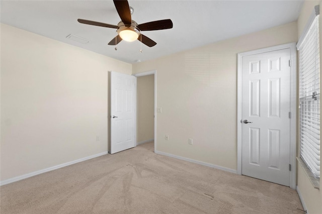 unfurnished bedroom with ceiling fan and light colored carpet