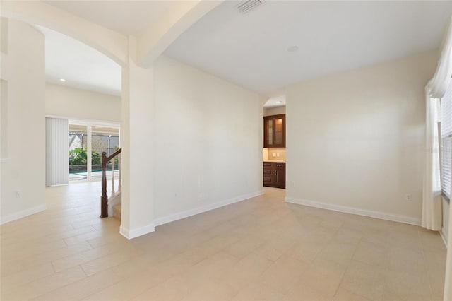 empty room featuring beamed ceiling