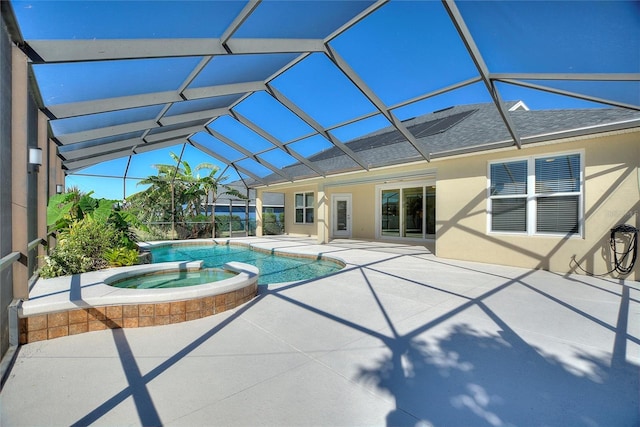 view of pool with an in ground hot tub, glass enclosure, and a patio