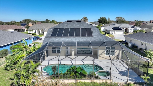 back of house featuring a patio, a pool with hot tub, and glass enclosure