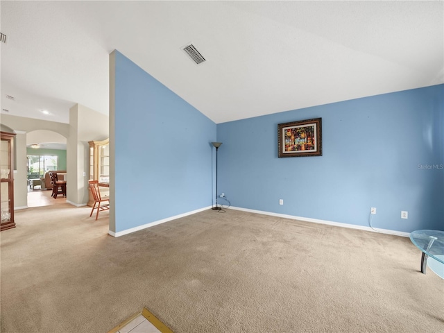 unfurnished room featuring carpet floors and lofted ceiling