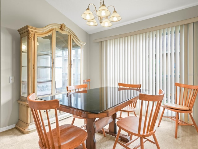 carpeted dining area featuring an inviting chandelier