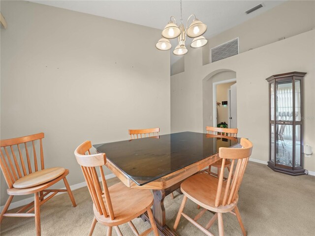 carpeted dining space featuring a notable chandelier