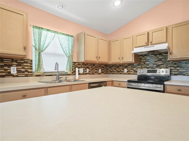 kitchen featuring appliances with stainless steel finishes, decorative backsplash, vaulted ceiling, and sink