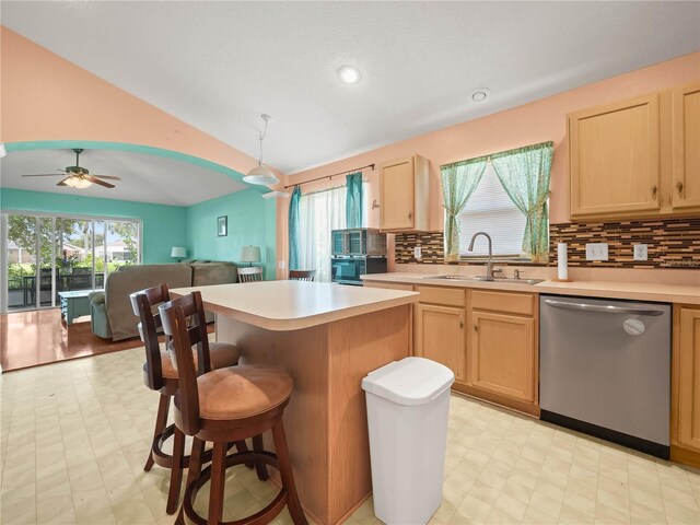 kitchen with dishwasher, a center island, sink, light brown cabinets, and ceiling fan