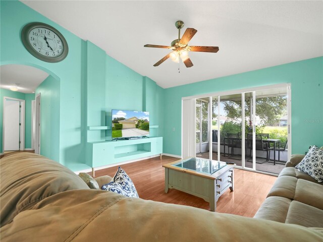 living room with ceiling fan, light hardwood / wood-style flooring, and vaulted ceiling