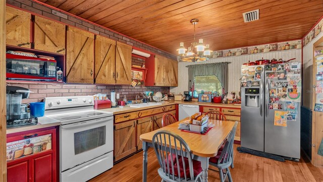 kitchen with white appliances, pendant lighting, light wood-type flooring, sink, and a chandelier