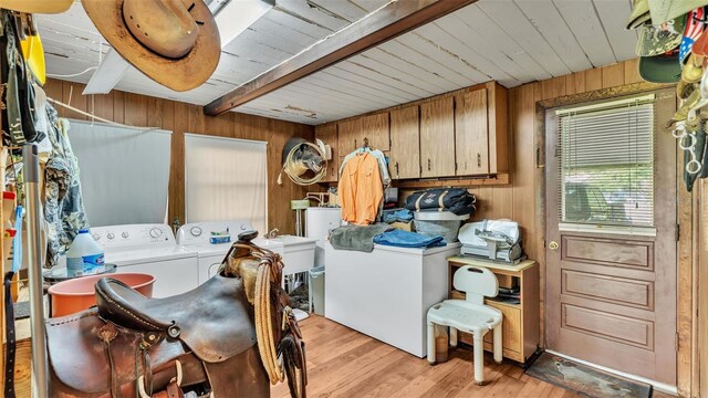 laundry room featuring light hardwood / wood-style floors, separate washer and dryer, wood walls, and wooden ceiling