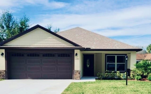 ranch-style home featuring a garage and a front yard