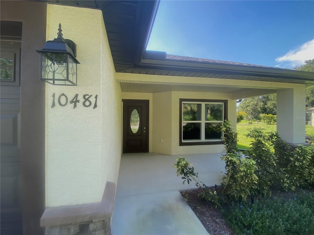 entrance to property featuring stucco siding