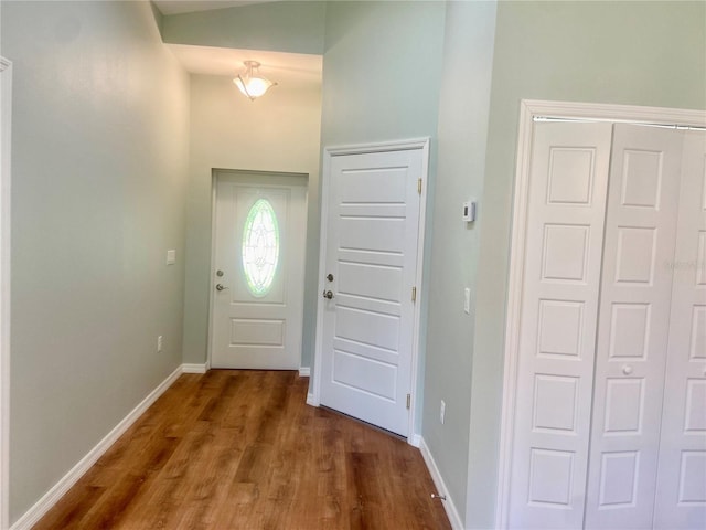 doorway with baseboards and dark wood finished floors