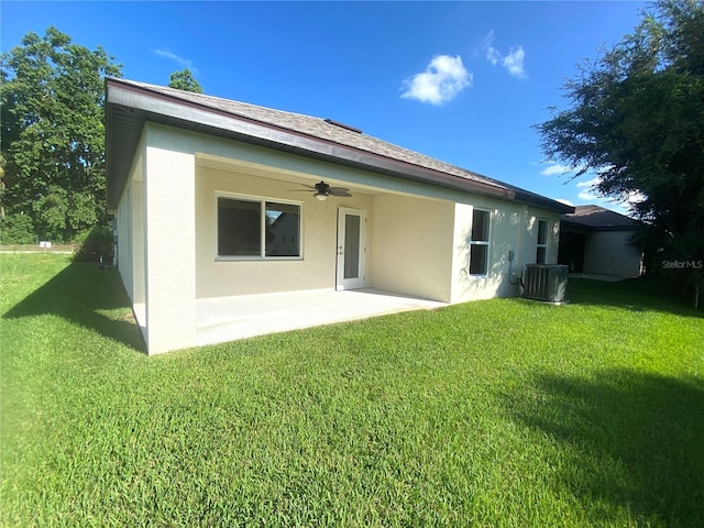 rear view of property featuring ceiling fan, a patio, cooling unit, a lawn, and stucco siding