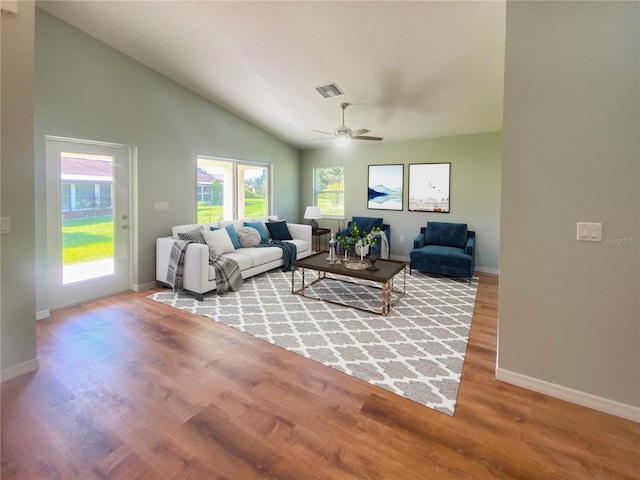 living room featuring baseboards, visible vents, ceiling fan, and wood finished floors