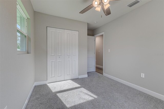 unfurnished bedroom featuring carpet floors, ceiling fan, and a closet