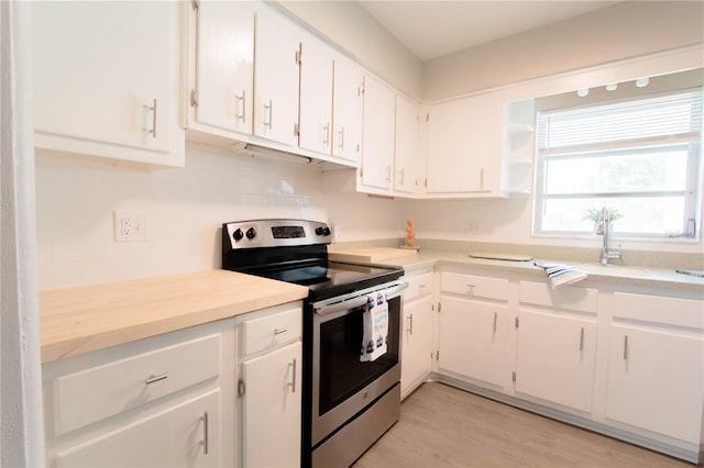 kitchen featuring light hardwood / wood-style flooring, white cabinets, and electric stove