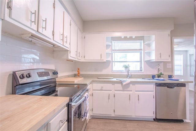 kitchen with sink, light hardwood / wood-style flooring, white cabinetry, stainless steel appliances, and decorative backsplash