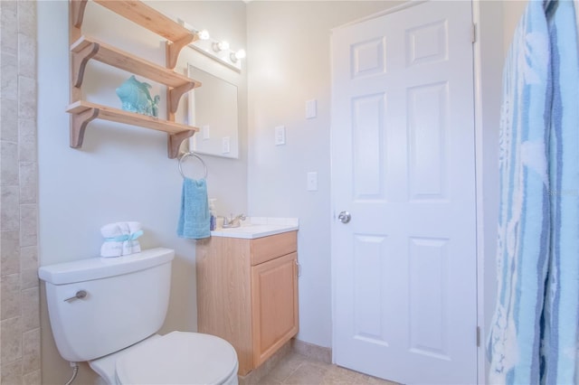 bathroom featuring tile patterned flooring, vanity, and toilet