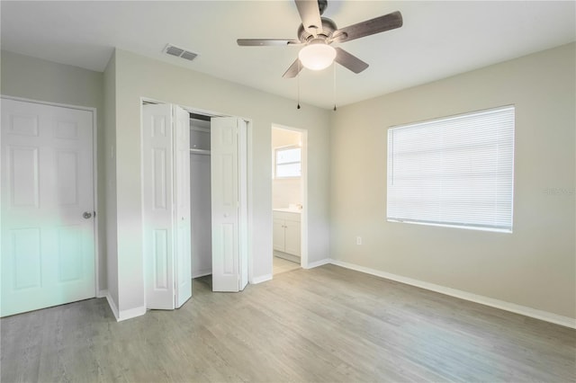 unfurnished bedroom featuring ceiling fan, light hardwood / wood-style flooring, and connected bathroom