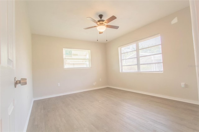 empty room featuring ceiling fan, light hardwood / wood-style flooring, and a wealth of natural light